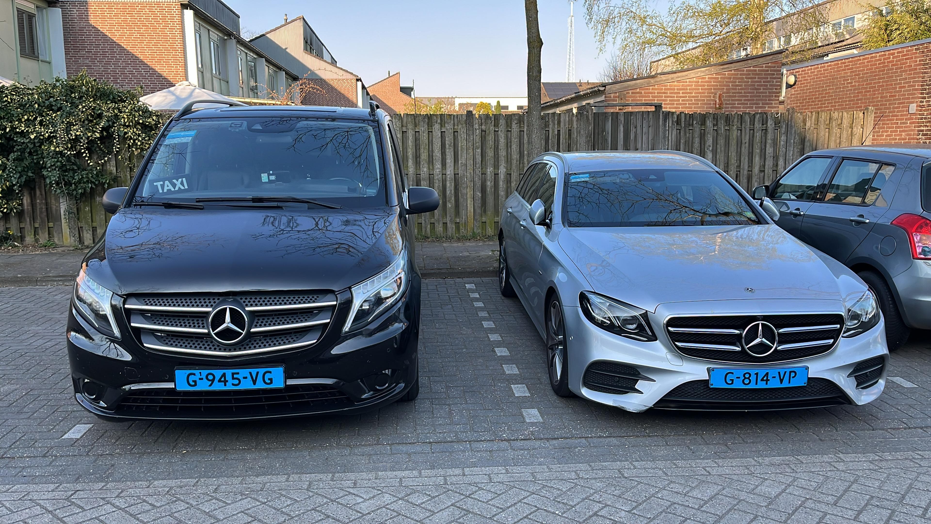 Black and silver Mercedes taxis parked side by side